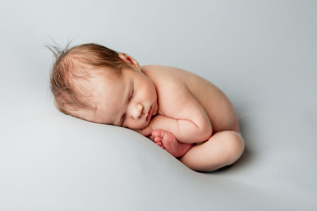 newborn boy in womb pose during newborn photography session