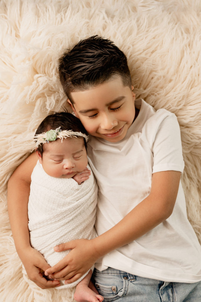 newborn baby girl with big brother during newborn photoshoot