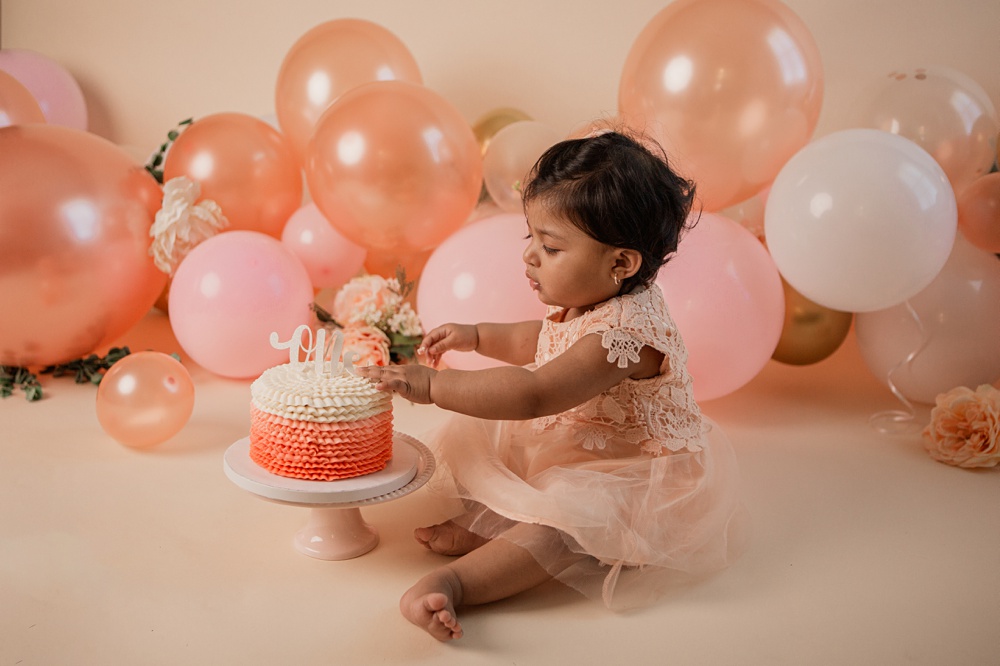Reaching for her cake at her cake smash session